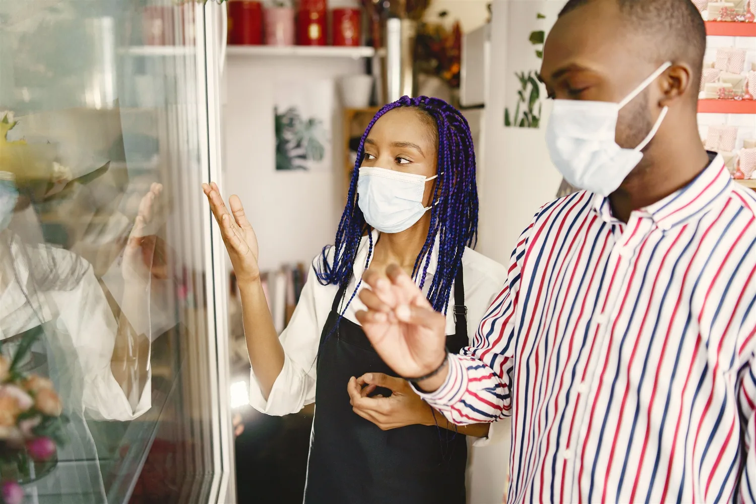 Two people talking beside a café display cabinet